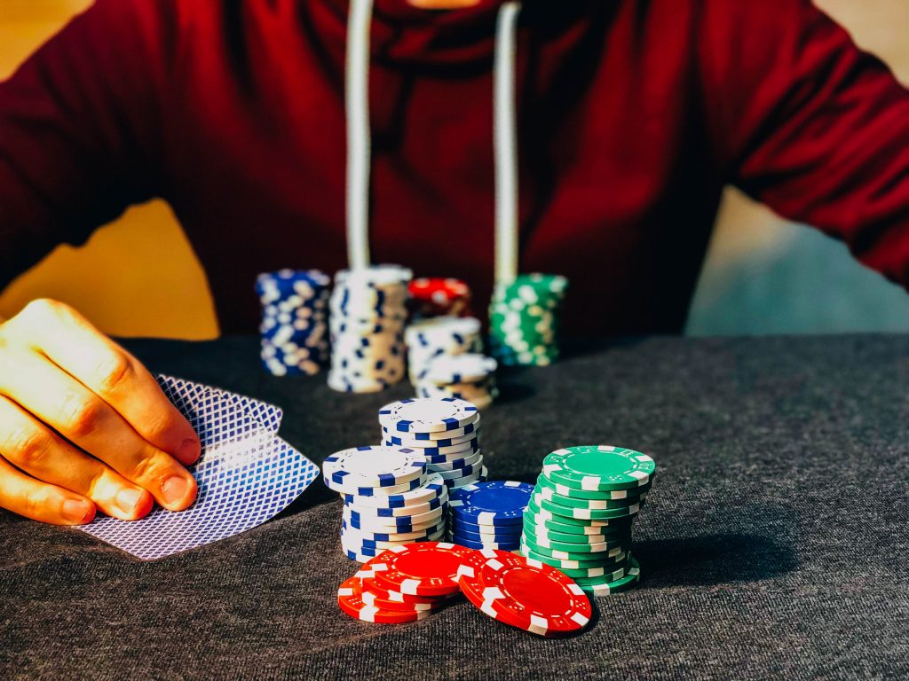 A set of poker chips in the table in front of player holding cards