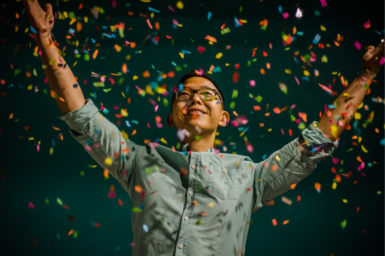 Man is surrounded by confetti flying through the air